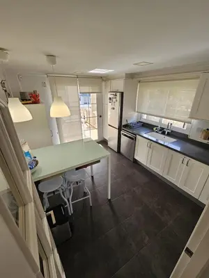 a kitchen with a table and a counter top at Amazing Villa with swimming pool in Torrent