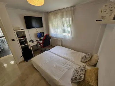 a bedroom with a bed and a desk with a computer at Amazing Villa with swimming pool in Torrent