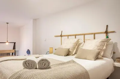 a bedroom with a large white bed with pillows at Lovely duplex on the beach in Valencia