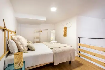 a bedroom with a large bed and a ladder at Lovely duplex on the beach in Valencia