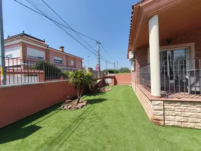a yard with green grass in front of a house at Villa Pepita in Torrent