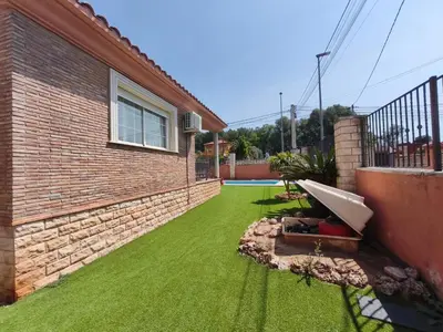 a garden with green grass next to a house at Villa Pepita in Torrent