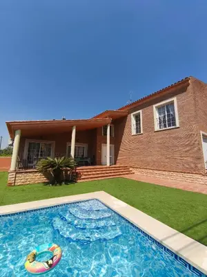 a swimming pool in front of a house at Villa Pepita in Torrent