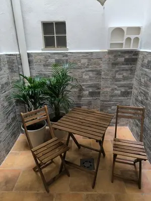 a wooden table and two chairs and a wooden table and chairs at Apartment next to the Marina De Valencia in Valencia