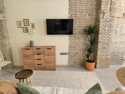 a living room with a television on a brick wall at Apartment next to the Marina De Valencia in Valencia