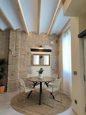a dining room with a table and chairs and a brick wall at Apartment next to the Marina De Valencia in Valencia