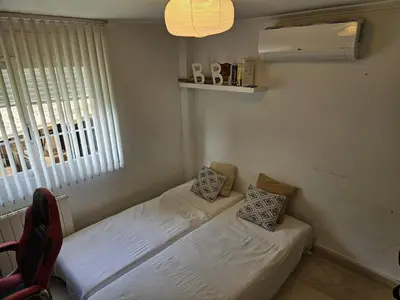 a room with two beds and a window and a chair at Amazing Villa with swimming pool in El Vedat de Torrente in Torrent