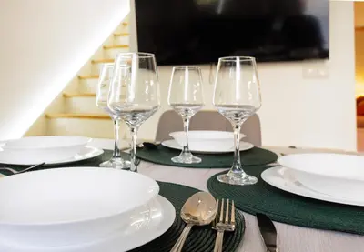 a table with four wine glasses and plates on it at Urban apartment 4 BAJO - Housevanlive in Valencia
