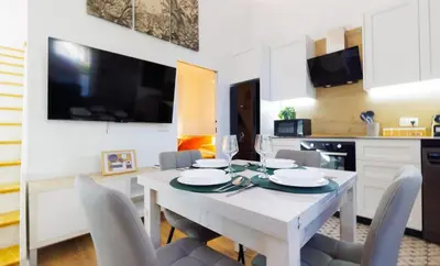 a dining room with a white table and chairs at Urban apartment 4 BAJO - Housevanlive in Valencia