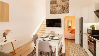 a kitchen and living room with a white table and chairs at Urban apartment 4 BAJO - Housevanlive in Valencia