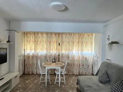 a small living room with a table and chairs at Apartamento edificio JUMAR in Cullera