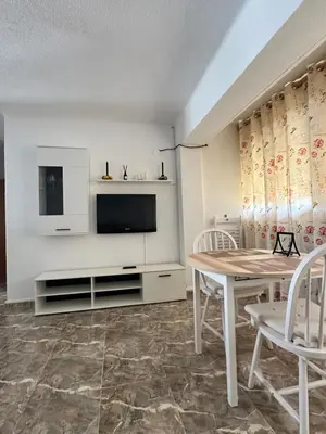 a living room with a table and a tv at Apartamento edificio JUMAR in Cullera
