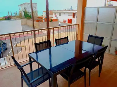 a glass table and chairs on a balcony with a view at Nules Beach Apartment in Moncófar