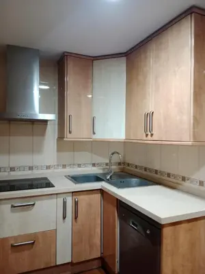 a kitchen with wooden cabinets and a sink at Nules Beach Apartment in Moncófar