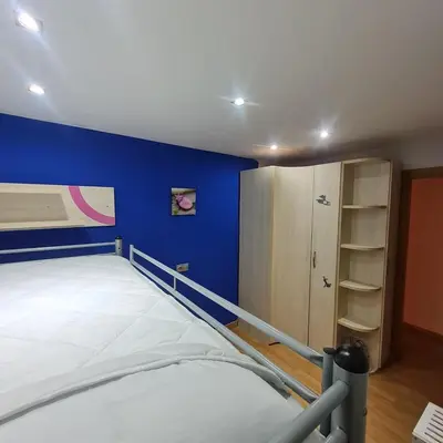a bedroom with a bed and a blue wall at Nules Beach Apartment in Moncófar