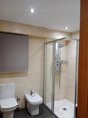 a bathroom with a toilet and a glass shower at Nules Beach Apartment in Moncófar