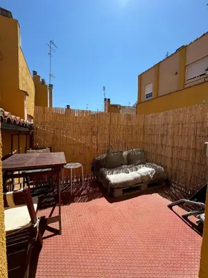 a couch on a patio with a wooden fence at Duplex Miguelete tower & 4th FLOOR and NO elevator in Valencia