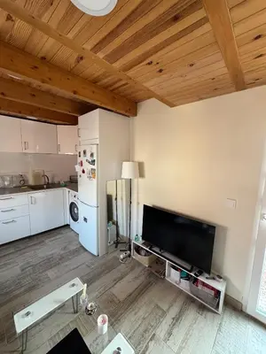 a living room with a large television and a kitchen at Duplex Miguelete tower & 4th FLOOR and NO elevator in Valencia