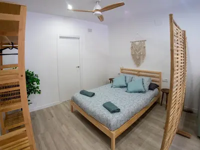 a bedroom with a bed with blue pillows at Boho Beach Flats in Valencia
