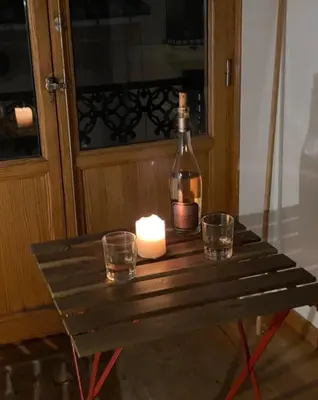 a candle and a bottle and glasses on a table at Bright, charming,in the historic center in Valencia