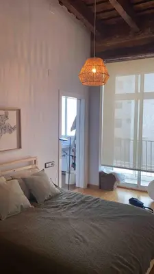 a bedroom with a large bed and a chandelier at Bright, charming,in the historic center in Valencia