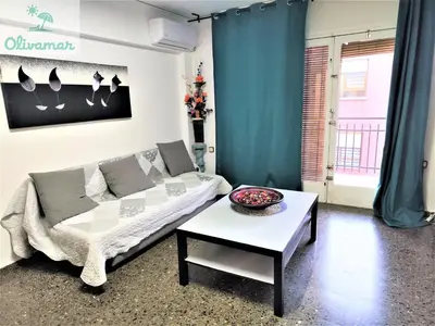 a living room with a couch and a table at Apartamento céntrico y cerca del mar en Tavernes in Tavernes de Valldigna