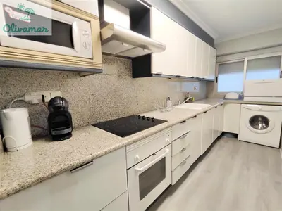 a kitchen with white cabinets and a stove top oven at Apartamento céntrico y cerca del mar en Tavernes in Tavernes de Valldigna