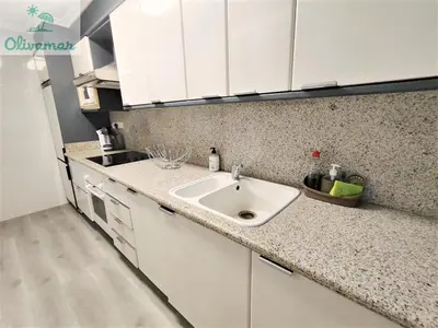 a kitchen with a sink and white cabinets at Apartamento céntrico y cerca del mar en Tavernes in Tavernes de Valldigna