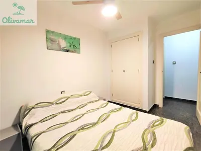 a bedroom with a bed and a door to a closet at Apartamento céntrico y cerca del mar en Tavernes in Tavernes de Valldigna