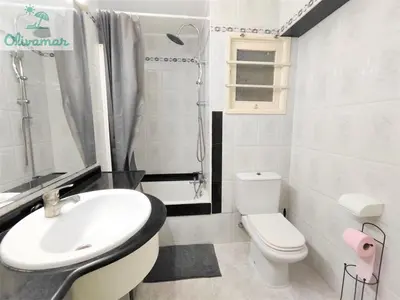 a white bathroom with a sink and a toilet at Apartamento céntrico y cerca del mar en Tavernes in Tavernes de Valldigna
