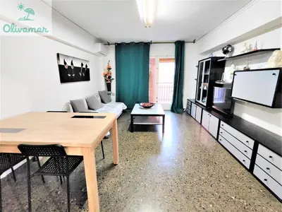 a living room with a table and a couch and a tv at Apartamento céntrico y cerca del mar en Tavernes in Tavernes de Valldigna