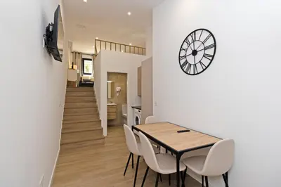 a dining room with a table and a clock on the wall at GuestReady - Beautiful loft in Valencia in Valencia
