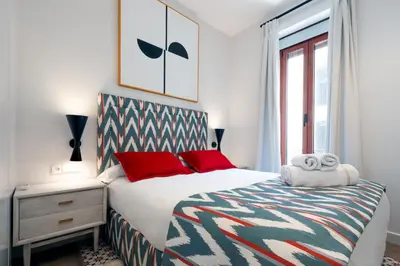 a bedroom with a bed with red pillows and a window at La Casa del Mar-Cabañal 3BR Suites in Valencia