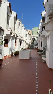 a street with white buildings and a brick sidewalk at Tranquil Coastal Living in Puebla de Farnals
