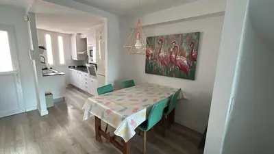 a dining room with a table and a kitchen at Tranquil Coastal Living in Puebla de Farnals