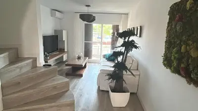 a living room with a couch and a tv at Tranquil Coastal Living in Puebla de Farnals
