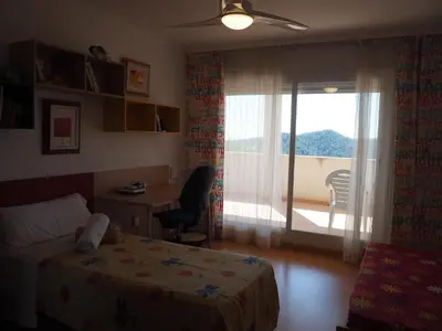 a bedroom with a bed and a desk and a window at Brisas de Sierra Calderona in Gilet