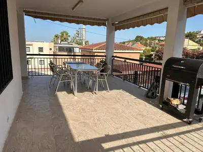 a patio with a table and chairs on a balcony at Chalet encanto in Chiva