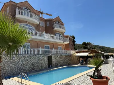 a large house with a swimming pool in front of it at Villa avec superbe vue in Cullera