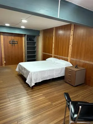 a large bedroom with a bed and a chair in it at Habitaciones Espacio in Corbera de Alcira