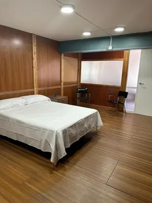 a bedroom with a bed and chairs in it at Habitaciones Espacio in Corbera de Alcira