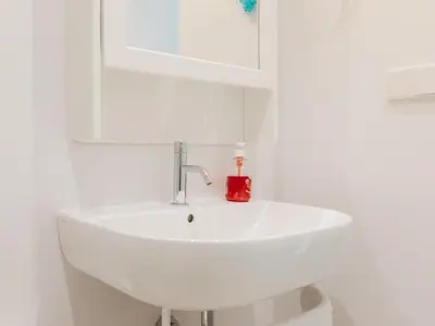 a white sink in a white bathroom with a red soap bottle at Marsalada 2 - Apartment with sea view in Playa de Mar