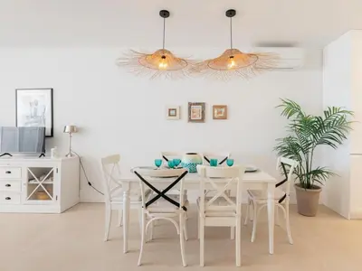 a white dining room with a white table and chairs at Marsalada 2 - Apartment with sea view in Playa de Mar