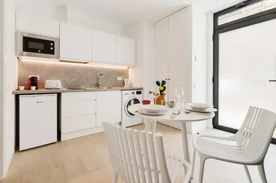 a kitchen with white cabinets and a white table and chairs at Fantástico loft en Valencia in Valencia