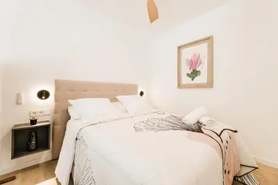 a white bedroom with a large bed with white sheets at Fantástico loft en Valencia in Valencia