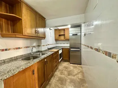 a kitchen with wooden cabinets and a stainless steel refrigerator at Casa Altura in Altura