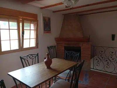 a dining room with a table and a fireplace at Casa Altura in Altura