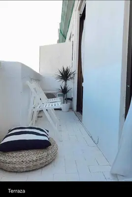 a pillow on a rattan chair on a patio at Welcome to your Home in Valencia