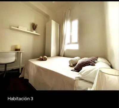 a white bedroom with a bed with a window at Welcome to your Home in Valencia