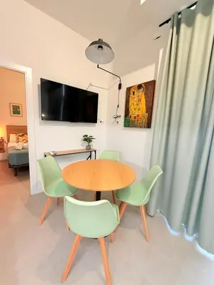 a dining room with a table and green chairs at Travel Habitat Oceanografic Suites in Valencia
